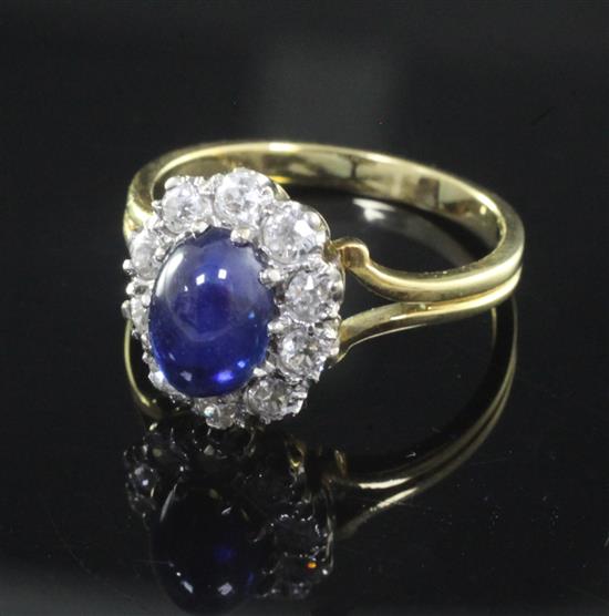 A cabochon sapphire and diamond cluster ring, size N.